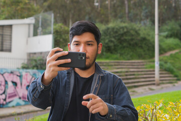 Young man walking in the woods taking selfies.