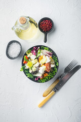 Traditional greek salad with fresh vegetables, feta and olives, on white background, top view flat lay