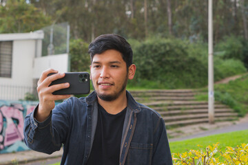 Young man walking in the woods taking selfies.