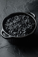 Bowl of black caviar, on black background