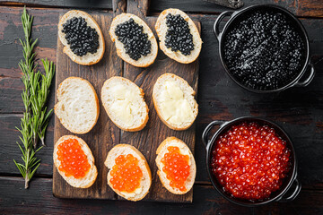 Sandwiches with red and black caviar  , on old dark  wooden table background, top view flat lay