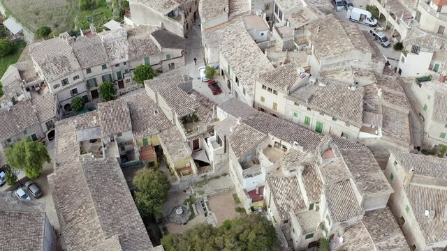 Architecture of European old village dron 4K video. Aerial view of a landscape with historic buildings and houses with tiled roofs on the streets where trees grow.