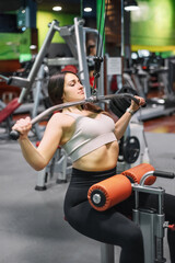 Fototapeta na wymiar Young sportswoman exercising on lat machine in gym. High quality photo