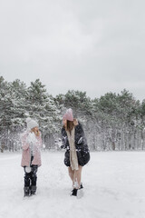 mother and child walking in winter forest