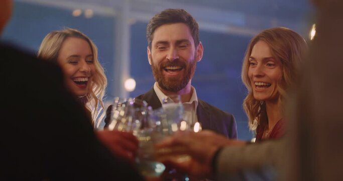 Diverse carefree candid millennial young people celebrating New Year corporate holiday in the company toasting alcohol drinks dancing together.