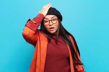 latin woman raising palm to forehead thinking oops, after making a stupid mistake or remembering,...