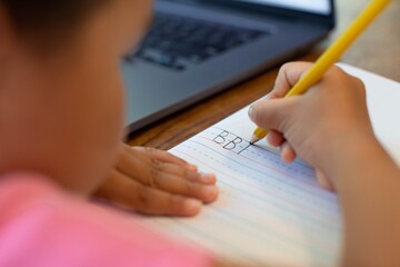Children learning how to write the alphabet, pencil and notebook. School online. Handwriting.