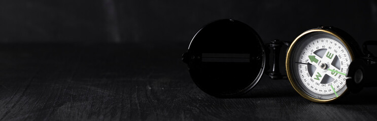panorama banner with antique compass with lid on the right with space for text on the left on black...