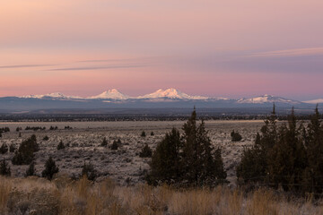 High desert landscape in early morning. Thee Sisters mountains on background. Central Oregon