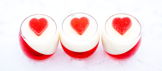panna cotta with red jelly candies in shape of hearts in snow