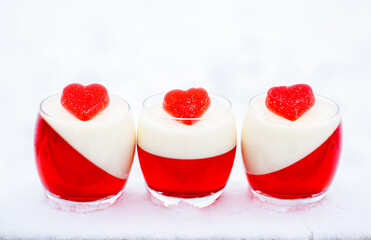 panna cotta with red jelly candies in shape of hearts in snow