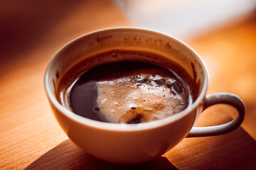 Beautiful cup of coffee with the foam in the morning and beautiful sunrise. Perfect way to start your day