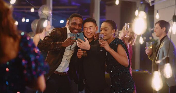 Multi-race friendly young handsome people trio making selfie picture on smartphone together enjoying corporate party event holiday.