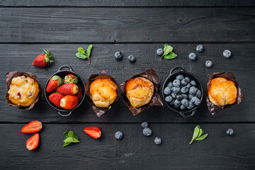 Blueberry muffins, on black wooden table background, top view flat lay with copy space for text