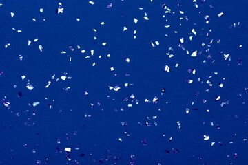 Beautiful festive blue background with metallic shaped confetti. Holiday decoration concept.