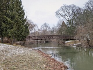 Fototapeta na wymiar park bridge over a river among the grey skies