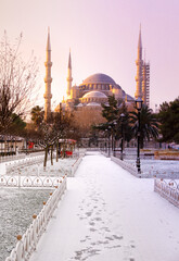 Fototapeta na wymiar Sun is rising near The blue mosque (in Turkish it is Sultanahmet mosque) in winter day with many snow in Istanbul,Turkey. January 2021.