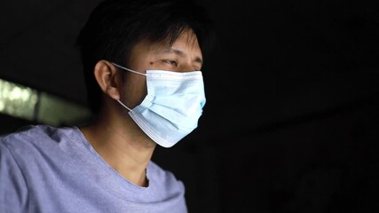 Young man working on a laptop at the night at home,  man wear face mask work from home - Powered by Adobe