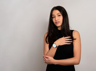 Beautiful young woman with long black hair wearing wirst watch, Youthful and radian girl with natural make-up