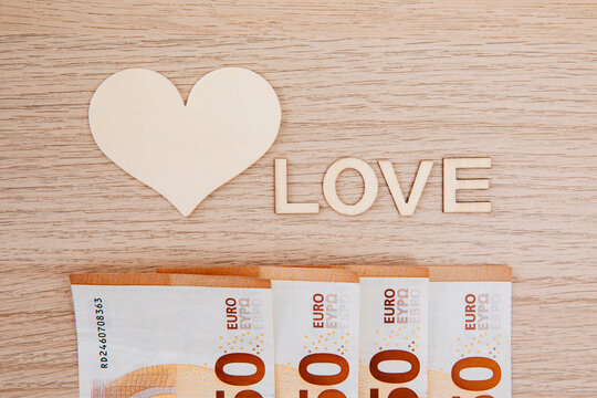 Euro banknotes next to the words "love". Hearts next to banknotes. Love money. concept of mercantilism  