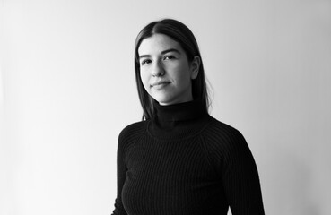 Black and white portrait of a young woman. she is wearing a black sweater