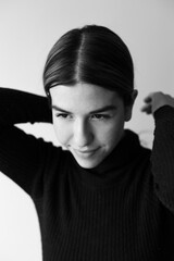 Black and white portrait of a young woman. she is wearing a black sweater