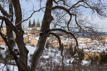 Fototapeta na wymiar Snowy Prague City with gothic Castle from Hill Petrin in the sunny Day, Czech republic