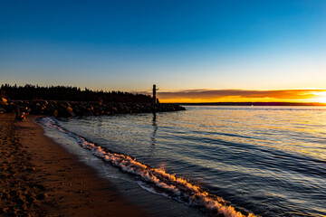 Welcome Totem Pole during sunset or dusk at Ambleside Beach, West Vancouver, BC Canada