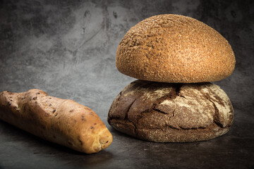 Wheat bread, rye round, French baguette with onions with a crisp crust on a gray mottled background