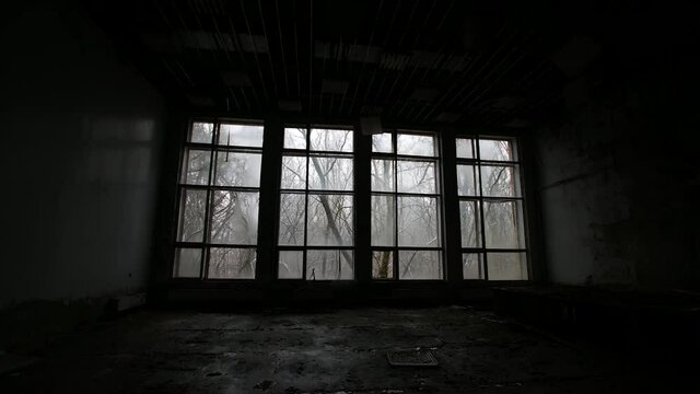 Dark windows with snow in hospital in Pripyat, chernobyl exclusion zone. Slow pan with dark, creepy feeling.