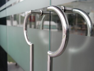 glass door with metal handles in office.