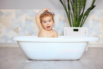 Naklejka premium happy baby bathes in the bathroom