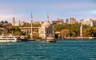 View on the bank of Bosporus Strait with touristic boat departing from Kabatas ferry terminal in front of Dolmabahce Mosque in Beyoglu district of Istanbul