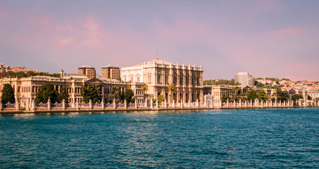 Obraz premium Sunset view on the bank of Bosporus Strait with glamorous Dolmabahce Palace, a museum in ornate Ottoman sultan palace in Besiktas district of Istanbul