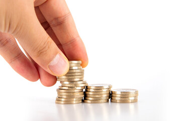 Hands continue to add coins to a stack of coins on a white background