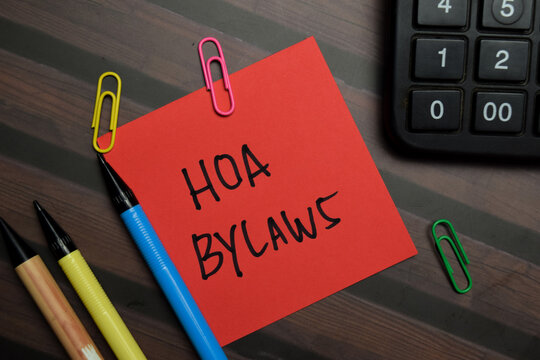 HOA Bylaws write on sticky notes isolated on Wooden Table.