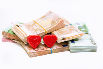 Stack pile of european money, Euro cash currency and two hearts on it isolated on white background
