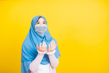 Woman wear hijab and face mask she henna decorated hands praying