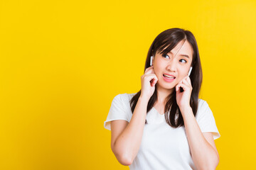 Young woman wear wireless earphone listening to music from smartphone having fun and dancing