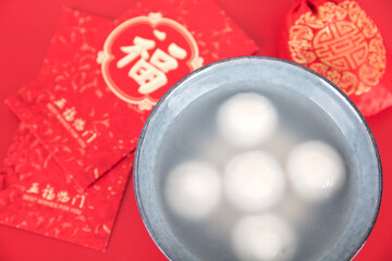 A bowl of lantern festival dumplings or Lantern Festival red envelopes on a red background