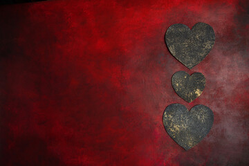 Fototapeta premium Three dsrk hearts on red vintage background. Card, place for text