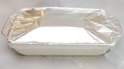 Baking dish covered with aluminum foil. Step by step beef lasagna recipe