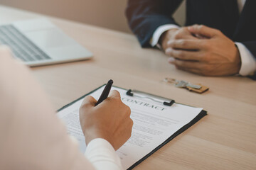Close up hand of tenant, client woman use the pen for sign signature contract rental house,...