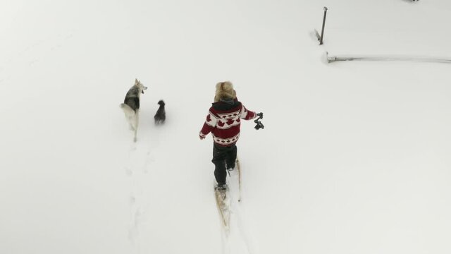 Adult man in large fur hat films himself walking in snow shoes with a DJI Ronin RSC 2 gimbal.