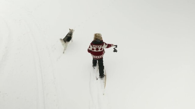 Adult man in large fur hat films himself walking in snow shoes with a DJI Ronin RSC 2 gimbal.