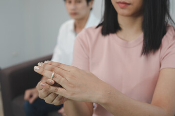 Unhappy young asian couples quarrel on the couch, relationships are in trouble. The wife holding...