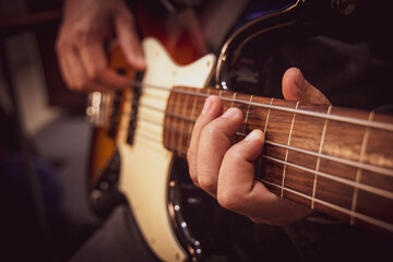 Obraz na płótnie Canvas Male hands playing fretless bass guitar