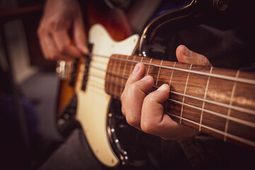 Fototapeta na wymiar Male hands playing fretless bass guitar