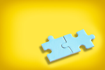 Fototapeta premium Blue puzzle jigsaw with shadow on yellow background. Business partnership concept and together solve problem idea