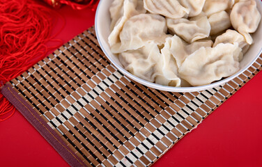 A plate of dumplings on a festive red background